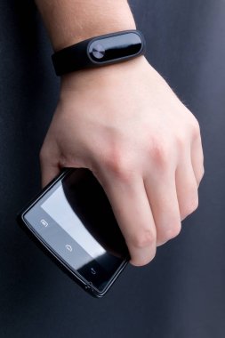 Mens el bir fitness izci ve smartphone. Yakın çekim.