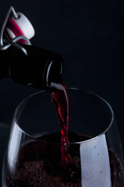 Close up de vinho tinto derramando em vidro . — Fotografia de Stock