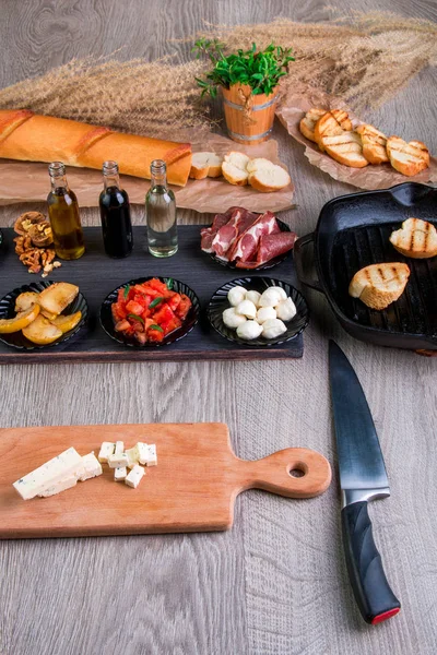 Bruschetta Ingredienti per la preparazione con tagliere e coltello. Cibo italiano. Antipasto . — Foto Stock