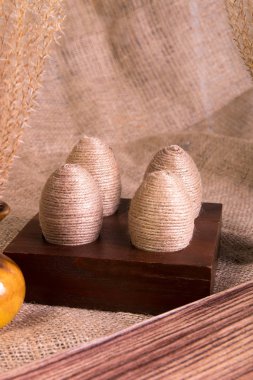Paskalya yumurtaları sicim çul arka plan üzerinde kahverengi ahşap stand içinde. Rustik tarzı.