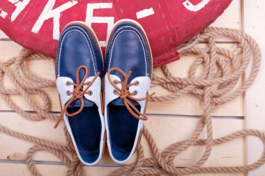 Lifebuoy ve ip ahşap zemin üzerine mavi ayakkabılar. Üstten Görünüm.