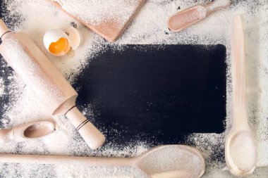 Mutfak eşyaları, un boşluk kopyalayın ve siyah arka plan üzerine yumurta. Üstten Görünüm. Çerçeve. Malzemeler ve araçlar için pişirme. 