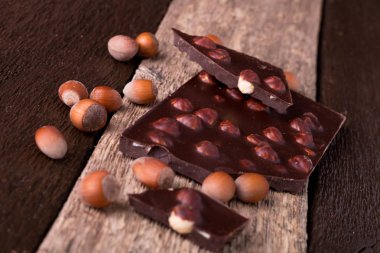 Ahşap arka plan üzerinde Fındıklı Fındıklı çikolata parçaları. 