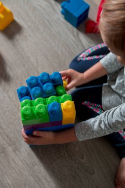 Eğlenceli ve parlak plastik inşaat yapı olan kız çocuk