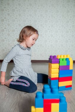 Eğlenceli ve parlak plastik inşaat yapı olan kız çocuk