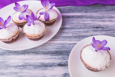 Ahşap açık mor renkli Çiğdem çiçek süslenmiş beyaz tabakta kek. Bahar. 