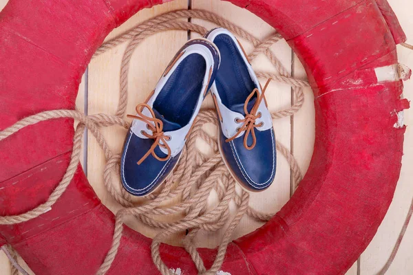 Kék csónak cipő, fa háttér piros mentőgyűrűt és a kötél. Szemközti nézet. — Stock Fotó