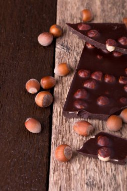 Ahşap arka plan üzerinde Fındıklı Fındıklı çikolata parçaları. 