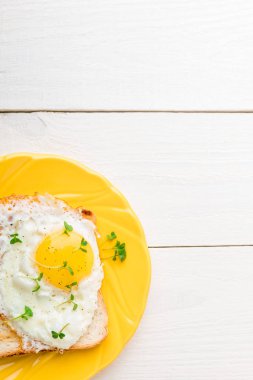 Yumurta beyaz ahşap zemin üzerinde mikro-yeşillik ile sarı plaka ile tost. Sağlıklı kahvaltı. Üstten Görünüm. Kopya alanı