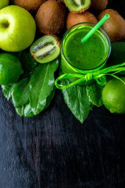 Yeşil smoothie malzemeler için o siyah ahşap zemin üzerine yakınındaki. Elma, limon, ıspanak, kivi. Detoks. Sağlıklı içecek. Üstten Görünüm. Kopya alanı.
