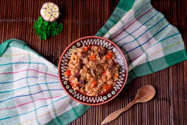 Ahşap bir masa, arka plan üzerinde kahverengi tabağa pilav. Rustik tarzı. Üstten Görünüm.