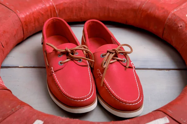 Zapatos de barco rojos sobre fondo de madera cerca de boya salvavidas. Vista superior. De cerca. . —  Fotos de Stock