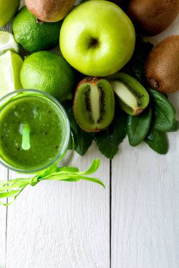 Yeşil smoothie yakınındaki beyaz ahşap zemin üzerinde bunun için malzemeler. Elma, limon, ıspanak. Detoks. Sağlıklı içecek. Üstten Görünüm.