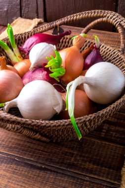 Farklı soğan sepeti ahşap arka plan üzerinde. Rustik tarzı. Yakın çekim
