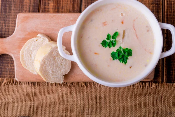 Soupe à la crème dans un bol blanc près du pain. Style rustique. Vue du dessus . — Photo