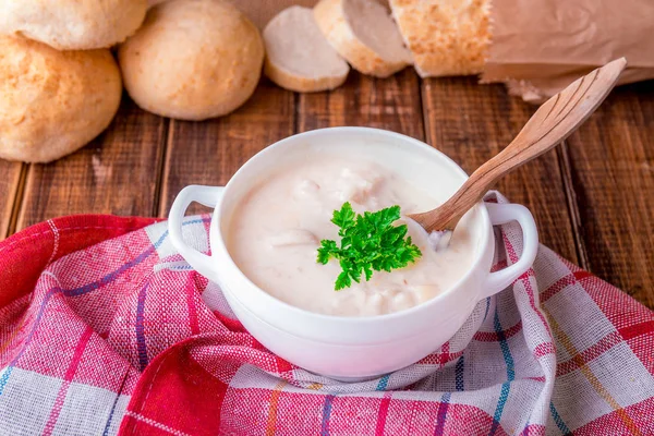 Σούπα με κρέμα γάλακτος σε λευκή μπολ με ξύλινο κουτάλι κοντά ψωμιού σε ξύλινα φόντο. Ρουστίκ στυλ — Φωτογραφία Αρχείου