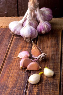 Sarımsak ahşap arka plan üzerinde sicim ile sarılmış. Rustik.