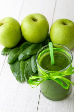Yeşil smoothie yakınındaki beyaz ahşap zemin üzerinde bunun için malzemeler. Elma, limon, ıspanak. Detoks. Sağlıklı içecek.