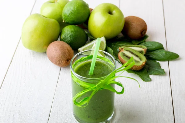 Batido verde cerca de los ingredientes para ello sobre fondo de madera blanca. Manzana, lima, espinacas. Desintoxicación. Bebida saludable . —  Fotos de Stock