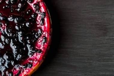 Cheesecake üzümü siyah ahşap arka plan ile. Üstten Görünüm. Kopya alanı.