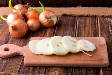 Soğan dilimleri rustik ahşap masa arka plan üzerinde.