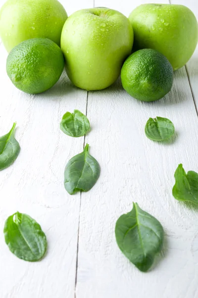 Зеленые плоды на белом деревянном фоне. Яблоко, лайм, шпинат. Детоксикация. Здоровое питание . — стоковое фото