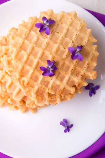Belgische wafels op wit bord versierd paarse bloem. Bovenaanzicht. — Stockfoto