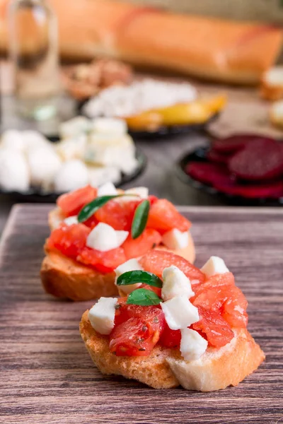 Bruschetta domates, mozzarella ve fesleğen ahşap arka plan üzerinde — Stok fotoğraf