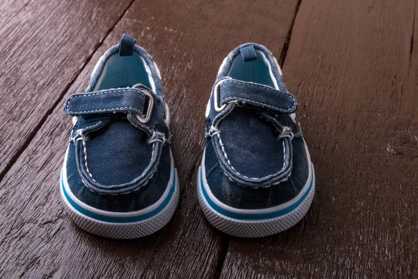 Blaue Bootsschuhe auf braunem Holzgrund. Junge Schuhe — Stockfoto