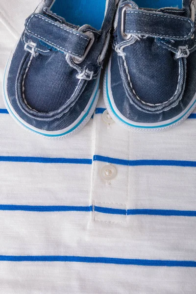 Zapatos de barco azul sobre fondo de polo rayado blanco. Traje de niño. Vista superior . —  Fotos de Stock