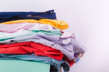 Renkli pantolon ve kot katlanmış. Parlak kadın pantolon yığını. Yakın çekim.