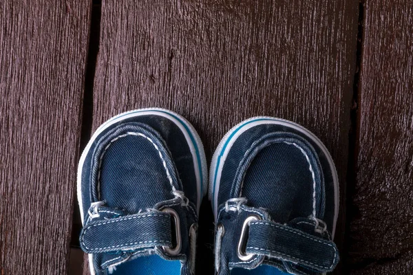 Blaue Bootsschuhe auf braunem Holzgrund. Junge Schuhe. Ansicht von oben. — Stockfoto