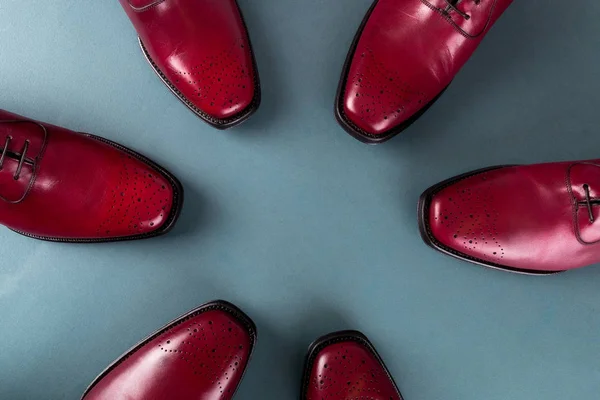 Three pair brogues in a circle. Red oxford shoes on blue background. Top view. — Stock Photo, Image