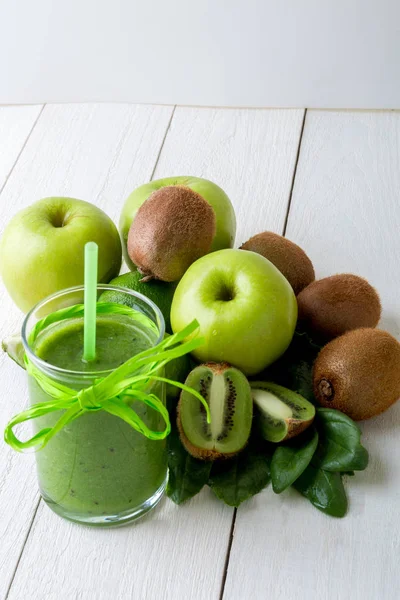 Batido verde cerca de los ingredientes para ello sobre fondo de madera blanca. Manzana, lima, espinacas. Desintoxicación. Bebida saludable . —  Fotos de Stock