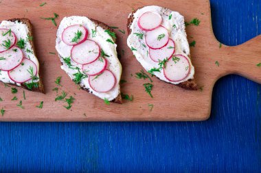 Mavi ahşap zemin üzerine kurulu turp peynirli sandviç. Üstten Görünüm. Kopya alanı.