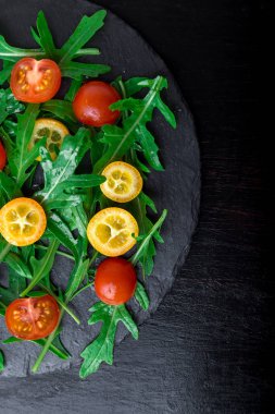 Roka Salatası ile kayrak plaka üzerinde Kamkat ve domates kiraz. Üstten Görünüm. Sağlıklı gıda. Diyet.