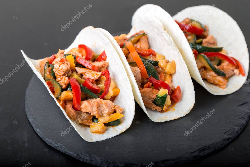 Mexican tacos with pork and vegetables. Al pastor taco on slate tableware