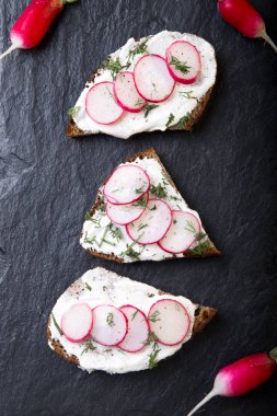 Siyah arduvaz arka planda turp peynirli sandviç. Üstten Görünüm.