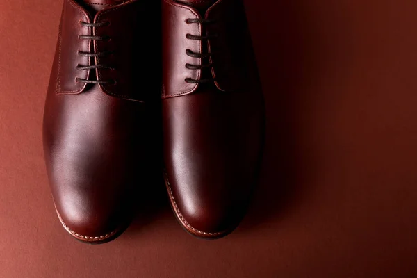 Brun oxford skor på röd bakgrund. Närbild. Ovanifrån. — Stockfoto