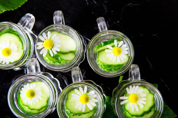 Agua de pepino en seis jarras de vidrio de albañil sobre fondo negro. Vista superior . — Foto de Stock