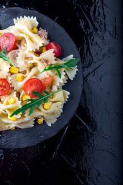 Kiraz domates, ton balığı, Mısır ve roka ile kayrak plaka makarna salatası. Üstten Görünüm. İtalyan yemeği. Kopya alanı.