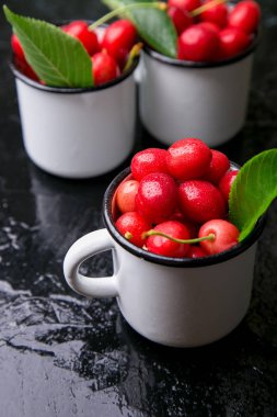 Kiraz emaye Kupası siyah arka plan üzerine. Sağlıklı, yaz meyve. Kiraz.