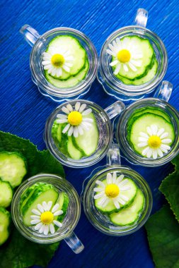 Salatalık suyu mavi zemin üzerine altı küçük mason cam kavanoza. Rustik. Üstten Görünüm. Detoks.