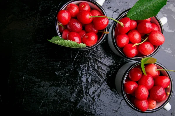 Kiraz emaye Kupası siyah arka plan üzerine. Sağlıklı, yaz meyve. Kiraz. Üstten Görünüm.