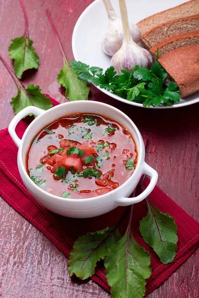 Традиційний український борщ. Російський вегетаріанські червоний суп в білі чаші на червоному тлі дерев'яні. Борщ, Борщ з буряка. — стокове фото