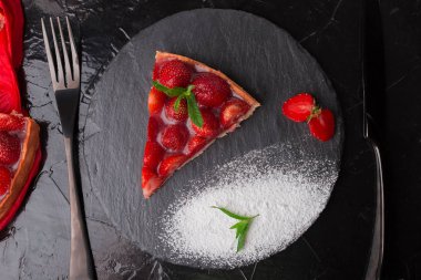 Çilekli pasta siyah arduvaz plaka üzerinde. Tek parça. Üstten Görünüm. 