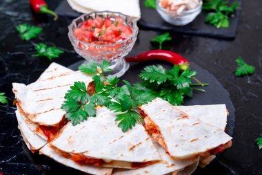 Mexican quesadilla siyah arduvaz taş plaka üzerinde salsa sos ile. Biber biber.