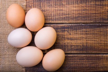 Taze yumurta buğday ahşap arka plan üzerinde yakın. Üstten Görünüm. Rustik. Kopya alanı.