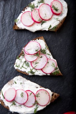 Siyah arduvaz arka planda turp peynirli sandviç. Üstten Görünüm.