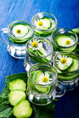 Salatalık suyu mavi zemin üzerine altı küçük mason cam kavanoza. Rustik. Detoks